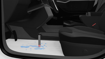 WLT 12 needle probe positioned above visible water on exposed metal floor in driver’s footwell, with WLT 200 tester indicating presence of water after automotive leak test