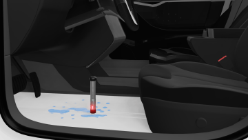 WLT 12.C needle probe with protective cover positioned above visible water on exposed metal floor in driver’s footwell, with WLT 200 tester indicating presence of water after automotive leak test